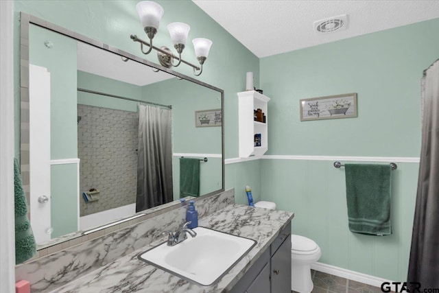 bathroom with an inviting chandelier, a shower with curtain, a textured ceiling, toilet, and vanity