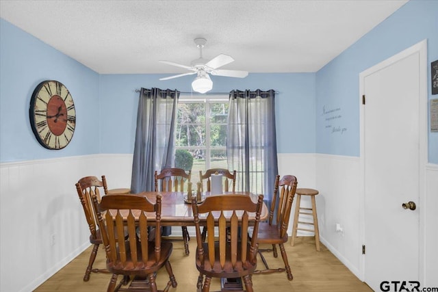 dining area featuring ceiling fan, a textured ceiling, and light hardwood / wood-style flooring