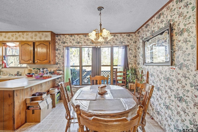 dining room featuring ornamental molding, a textured ceiling, and a notable chandelier