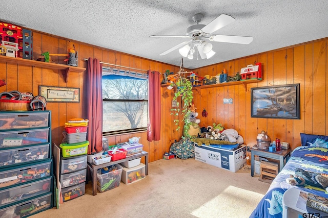 bedroom with carpet flooring, ceiling fan, wooden walls, and a textured ceiling