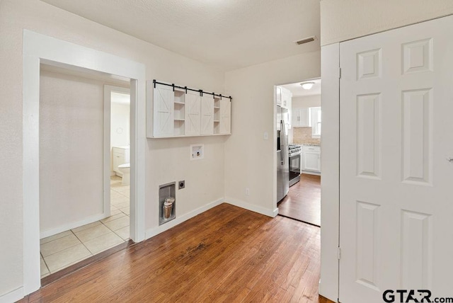 washroom featuring hardwood / wood-style floors, washer hookup, and electric dryer hookup