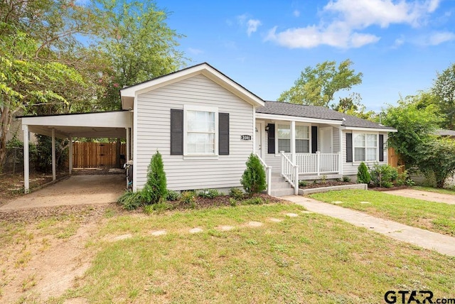 single story home featuring a carport, covered porch, and a front lawn