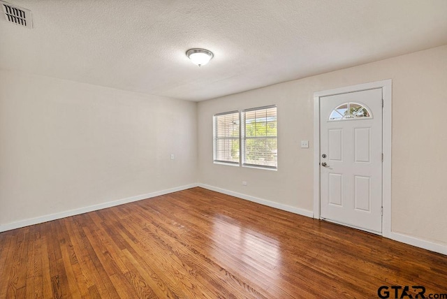 foyer entrance with a textured ceiling and hardwood / wood-style flooring