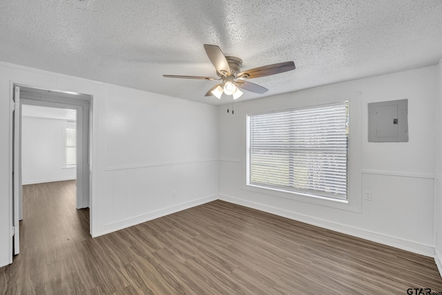 1005 N Rodeo St, Gladewater, TX 75647 - empty room with electric panel, ceiling fan, wood finished floors, a textured ceiling, and healthy amount of natural light