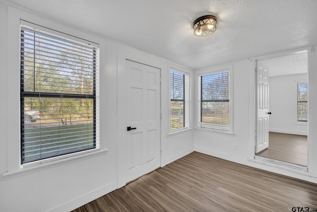 1005 N Rodeo St, Gladewater, TX 75647 - entrance foyer with a textured ceiling, wood finished floors, and baseboards