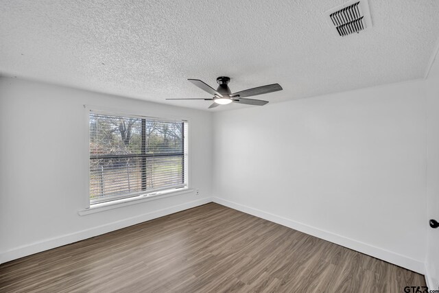 1005 N Rodeo St, Gladewater, TX 75647 - spare room with wood finished floors, a ceiling fan, a textured ceiling, and baseboards
