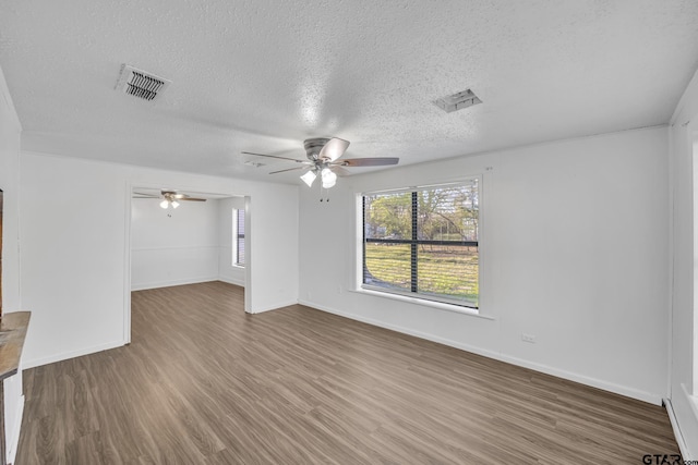 1005 N Rodeo St, Gladewater, TX 75647 - unfurnished living room featuring a ceiling fan, wood finished floors, a textured ceiling, and baseboards