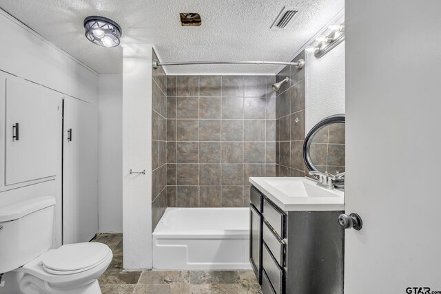 1005 N Rodeo St, Gladewater, TX 75647 - full bathroom with a textured ceiling, toilet, vanity, and tub / shower combination