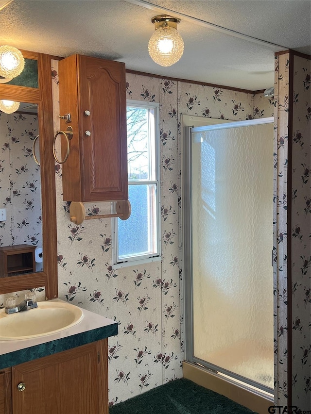 bathroom featuring a textured ceiling, vanity, and an enclosed shower