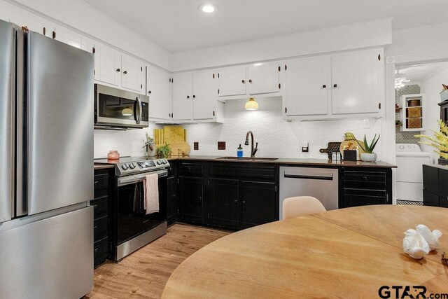 1510 Hideaway Ln W, Hideaway, TX 75771 - kitchen with appliances with stainless steel finishes, a sink, light wood-type flooring, ornamental molding, and white cabinetry