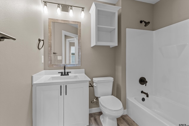 full bathroom with wood-type flooring, washtub / shower combination, vanity, and toilet