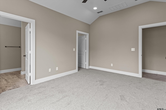 unfurnished bedroom featuring ceiling fan, light colored carpet, and vaulted ceiling