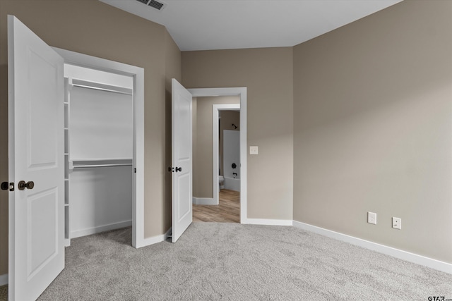 unfurnished bedroom featuring a closet and light carpet