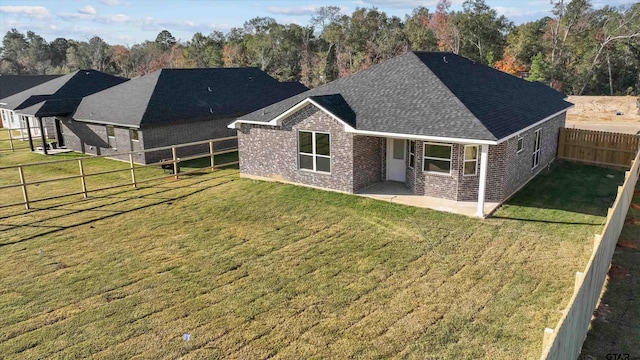 back of house featuring a patio area and a lawn