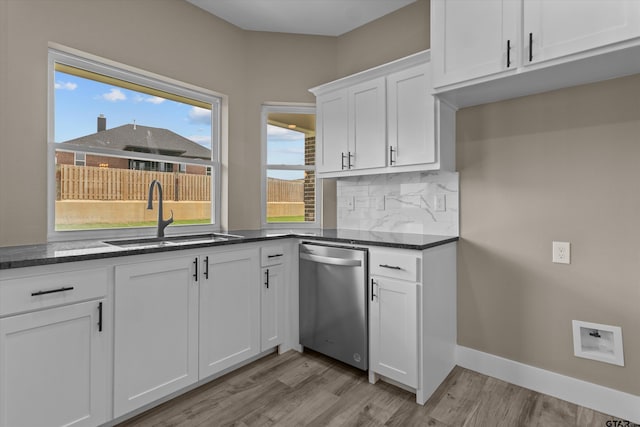 kitchen featuring stainless steel dishwasher, sink, backsplash, white cabinets, and light hardwood / wood-style floors