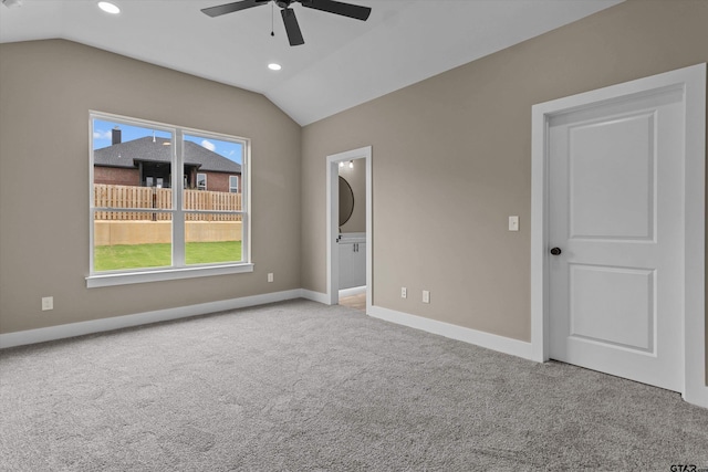 spare room with ceiling fan, light colored carpet, and lofted ceiling