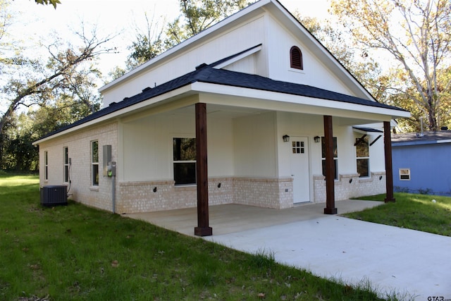 view of front facade with covered porch, a front lawn, and central air condition unit