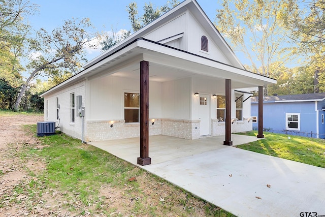 view of front of home featuring a porch, central AC unit, and a front yard