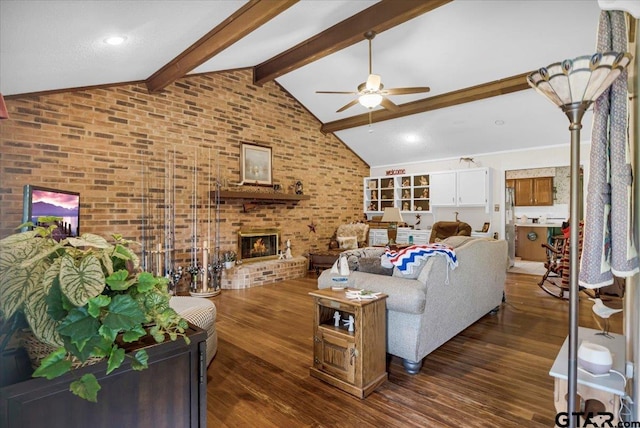 5626 Meadowdale Rd, Flint, TX 75762 - living area with ceiling fan, beamed ceiling, a fireplace, dark wood-type flooring, and brick wall