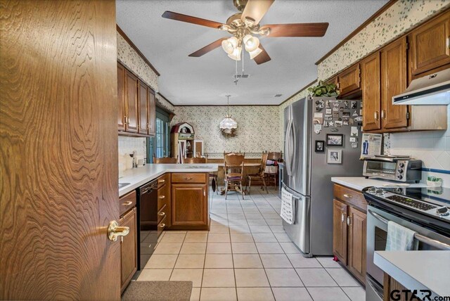 5626 Meadowdale Rd, Flint, TX 75762 - kitchen with wallpapered walls, stainless steel appliances, light countertops, a ceiling fan, and brown cabinetry