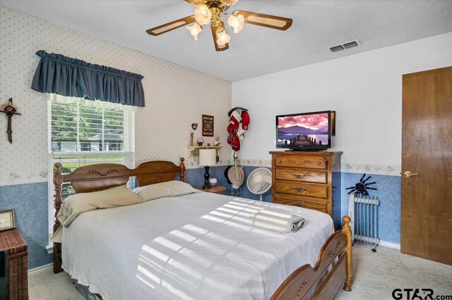 5626 Meadowdale Rd, Flint, TX 75762 - carpeted bedroom with wallpapered walls, radiator, and a ceiling fan