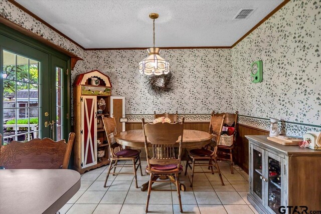 5626 Meadowdale Rd, Flint, TX 75762 - dining area with wallpapered walls, crown molding, wainscoting, a textured ceiling, and a chandelier