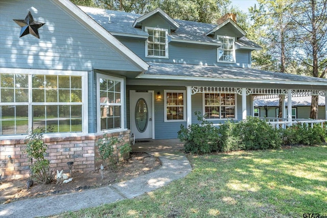 2222 County Road 1570, Alba, TX 75410 - view of front of house featuring a porch, a front yard, a chimney, and roof with shingles