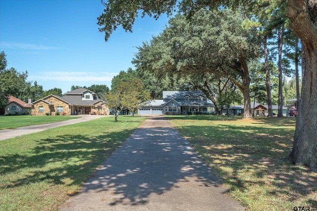 2222 County Road 1570, Alba, TX 75410 - view of front of home featuring stone siding, driveway, a front yard, and an attached garage