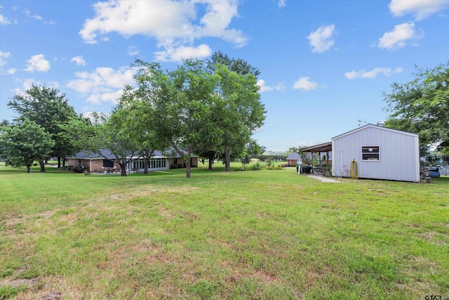 view of yard featuring a carport and an outbuilding