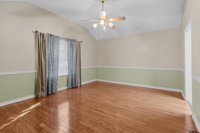 spare room featuring ceiling fan, light wood-type flooring, and vaulted ceiling