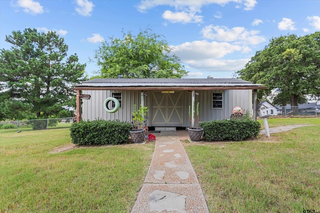 view of front of home with an outbuilding and a front lawn