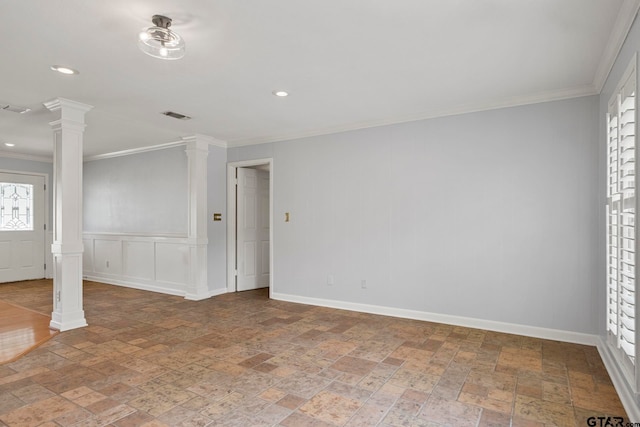 unfurnished room with crown molding and decorative columns