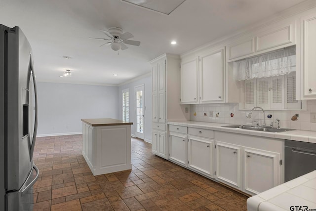 kitchen with white cabinetry, sink, appliances with stainless steel finishes, tasteful backsplash, and tile counters