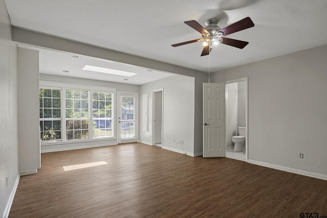 909 Elizabeth St, Gilmer, TX 75644 - spare room featuring wood finished floors, baseboards, ceiling fan, and a skylight