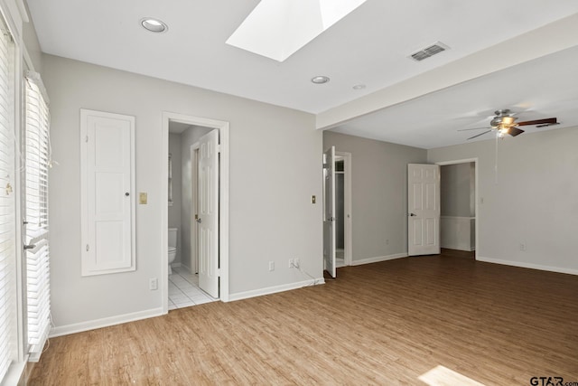 909 Elizabeth St, Gilmer, TX 75644 - unfurnished bedroom with a skylight, light wood-type flooring, recessed lighting, and baseboards