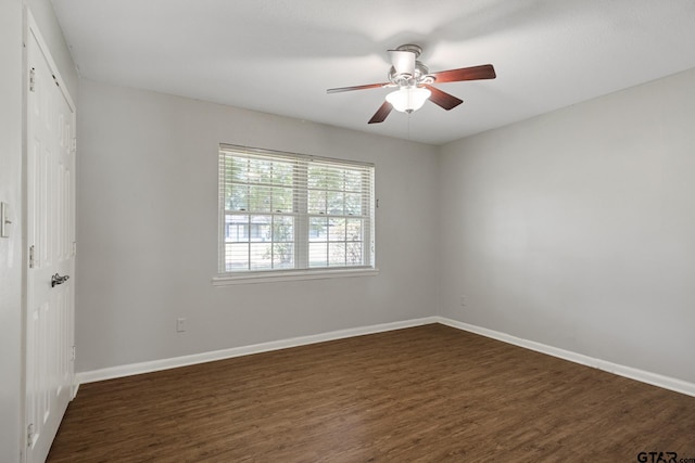 909 Elizabeth St, Gilmer, TX 75644 - unfurnished bedroom featuring dark wood finished floors, a closet, baseboards, and a ceiling fan