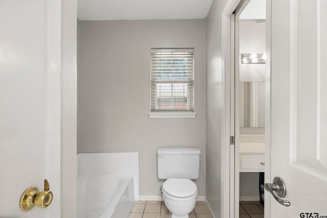 bathroom featuring a bathing tub, tile patterned flooring, vanity, and toilet