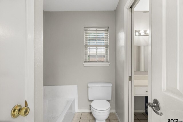 909 Elizabeth St, Gilmer, TX 75644 - full bathroom featuring tile patterned floors, a bath, toilet, and baseboards