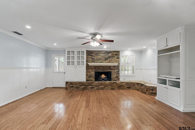 909 Elizabeth St, Gilmer, TX 75644 - unfurnished living room featuring healthy amount of natural light, a ceiling fan, a wainscoted wall, light wood-type flooring, and crown molding