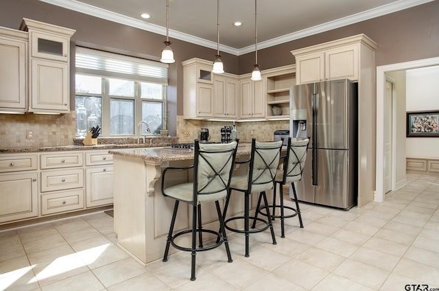 kitchen with decorative light fixtures, stainless steel fridge with ice dispenser, a kitchen island, light stone countertops, and a kitchen breakfast bar