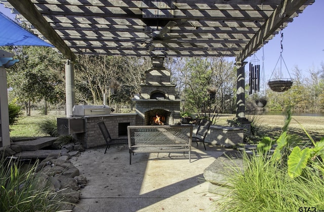 view of patio / terrace featuring a warm lit fireplace, area for grilling, and a pergola