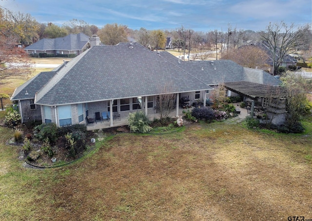 back of property with a lawn and a patio