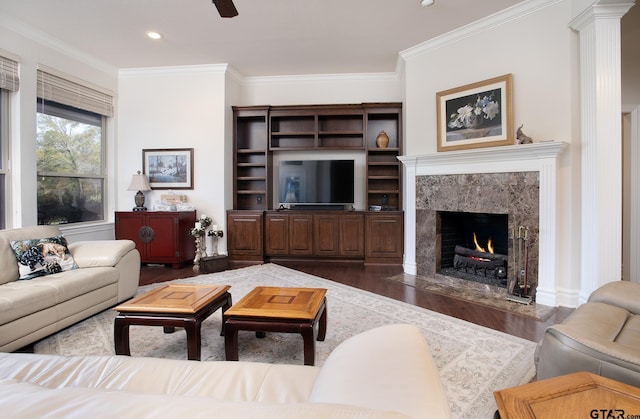 living area featuring dark wood-style flooring, a fireplace, recessed lighting, ornamental molding, and a ceiling fan