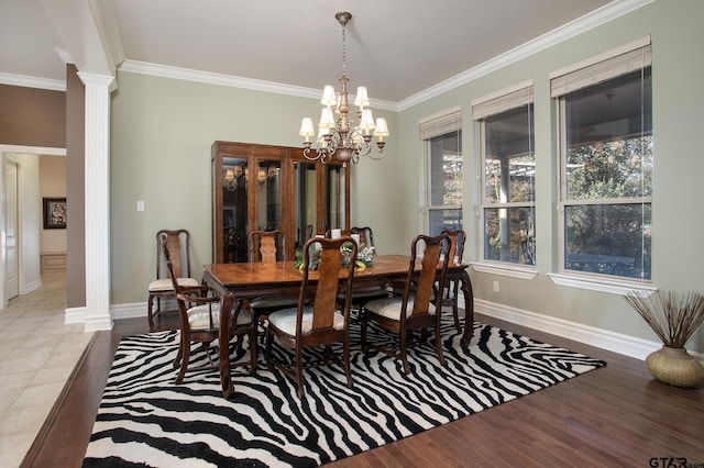 dining room with crown molding, light wood-style flooring, a wealth of natural light, and ornate columns