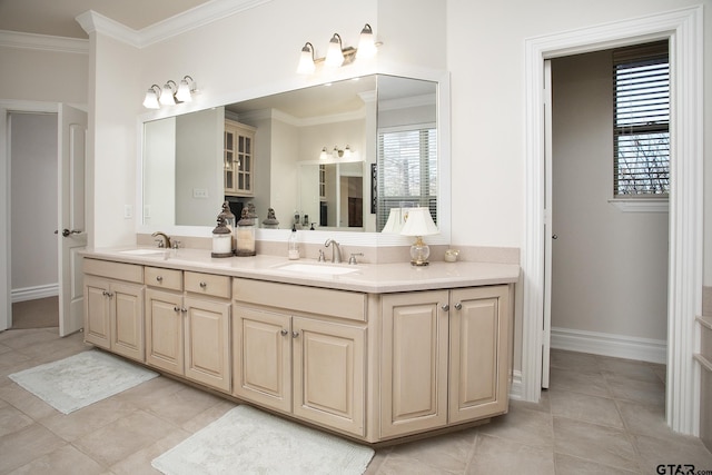 bathroom featuring double vanity, ornamental molding, a sink, and baseboards