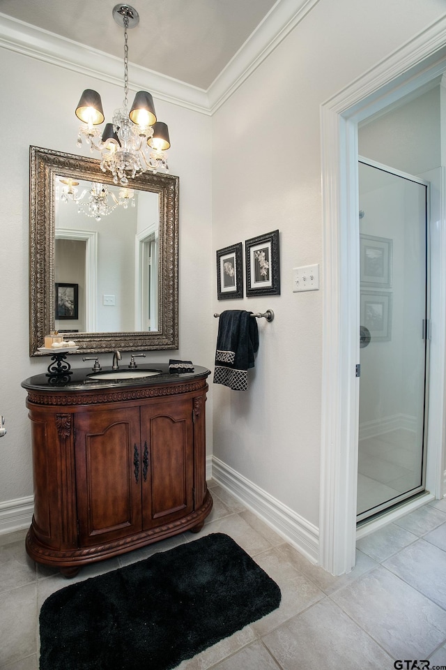 bathroom featuring tile patterned flooring, vanity, baseboards, ornamental molding, and a shower stall