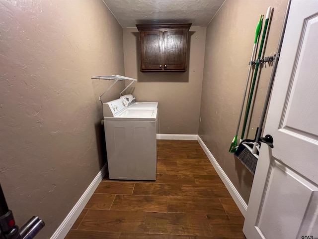 laundry area with washing machine and clothes dryer, dark wood-type flooring, and a textured ceiling