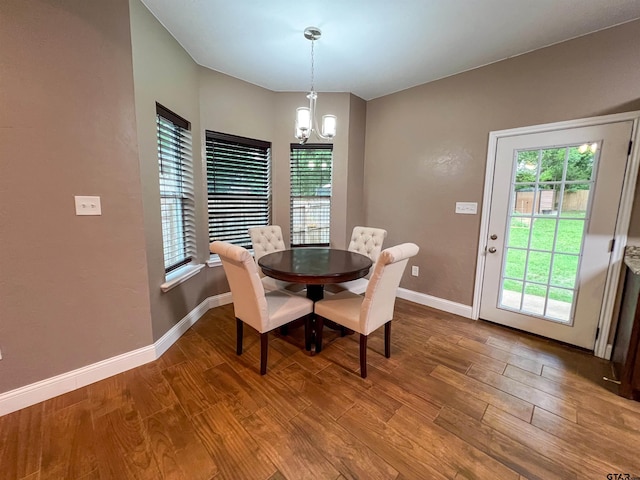 dining area with wood-type flooring and a chandelier