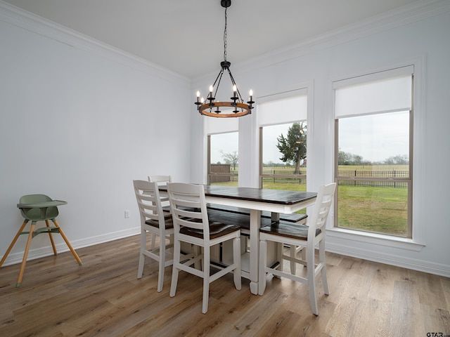 dining area with a notable chandelier, wood finished floors, and ornamental molding