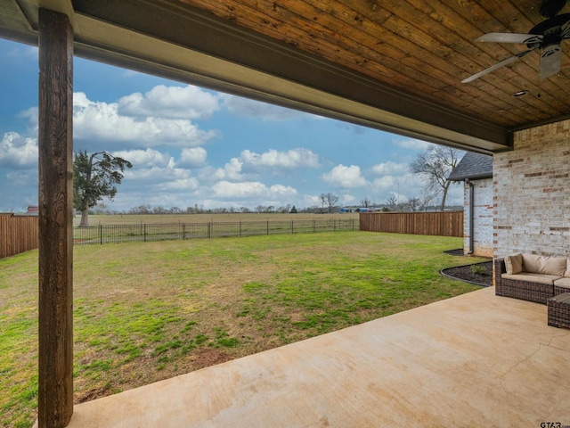 view of yard with a patio area, a fenced backyard, a rural view, and ceiling fan